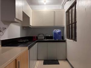 a kitchen with white cabinets and a sink at Travellers Staycation in San Jose del Monte