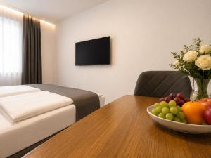 a hotel room with a table with a bowl of fruit at Hotel Drei Könige in Chur