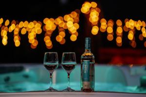 a bottle of wine and two glasses on a table at Zöldpart Villa in Balatonszárszó +31 photos