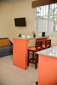 a living room with an orange counter and chairs at Elementz Apartments in Paramaribo