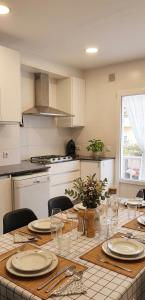 a kitchen with a table with plates and wine glasses at Casa junto al mar in Vinarós +20 photos