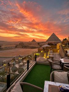 a balcony with a view of the pyramids at sunset at Hermes On The Spot Pyramids Hotel in Cairo