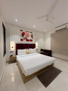 a bedroom with a large white bed and a couch at Hotel Amber Inn - 800m from Prayagraj Junction in Prayagraj