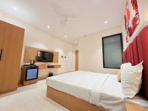 a bedroom with a large bed and a tv at Hotel Amber Inn - 800m from Prayagraj Junction in Prayagraj