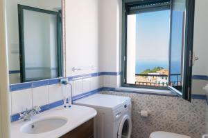 a bathroom with a sink and a washing machine at Cresta Panoramic apartments in Naso +37 photos