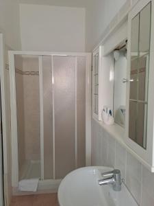 a bathroom with a shower and a white sink at Hotel Le Onde in Terracina