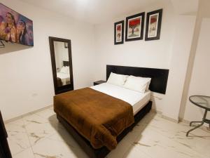 a bedroom with a bed and a mirror and a chair at SANCA HOUSE Hostel in Trujillo