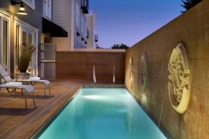 a swimming pool with chairs next to a building at InterContinental The Clement Monterey by IHG in Monterey