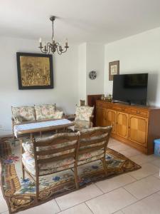 a living room with a table and chairs and a television at Haus Else am Nationalpark Eifel in Schleiden
