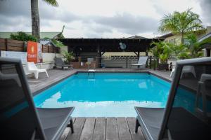 a large blue swimming pool with chairs around it at Elementz Apartments in Paramaribo
