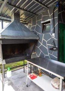 an outdoor grill with a table in front of a wall at AAA Byurakan Rest House in Ashtarak
