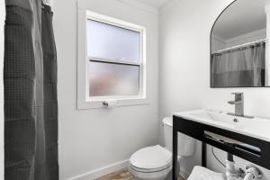 a bathroom with a toilet and a sink and a window at Copper Hill Suites in Butte