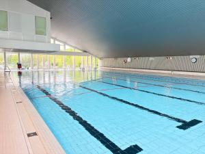 a large swimming pool with blue water in a building at Panoramic App C09-8 in Sierksdorf