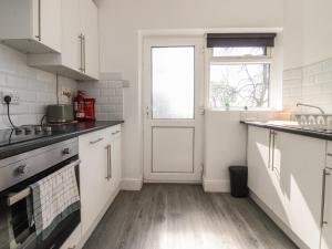 a kitchen with white cabinets and a door at Beacon Fell Cottage 1 in Preston