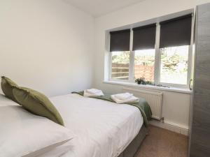 two beds in a room with a window at Beacon Fell Cottage 1 in Preston