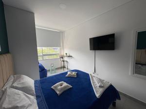 a bedroom with a blue bed with two towels on it at alojamientos la martina in Cali