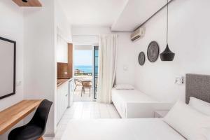a white room with a bed and a table at Elvita beach hotel in Lartos +17 photos
