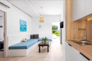 a bedroom with a blue bed in a white room at Elvita beach hotel in Lartos