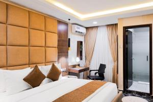 a hotel room with a bed and a desk at BON Hotel Kabuwol in Ibadan +28 photos