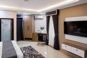 a hotel room with a bed and a flat screen tv at BON Hotel Kabuwol in Ibadan