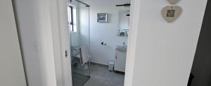 a white bathroom with a toilet and a sink at Sonrisa on Point in Stompneusbaai