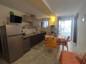 a small kitchen with a table and a refrigerator at Appartamenti Conchiglie e Stelle Marine in Cala Gonone
