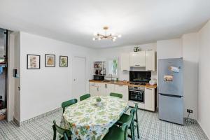 a kitchen with a table and a refrigerator at La Casa Del Bosco - Two floors home in Naples