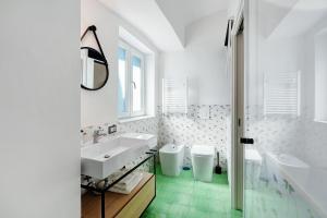 a white bathroom with two sinks and two toilets at La Casa Del Bosco - Two floors home in Naples +19 photos