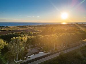 an aerial view of the sun setting over the ocean at Villa Fefè in Nardò