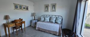 a bedroom with a bed and a table and a desk at Sonrisa on Point in Stompneusbaai