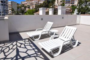 two white chairs and a table on a roof at Letplanet Playa Park in Torremolinos