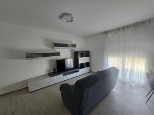 a white living room with a couch and a television at Levante Land & Sea in Bari