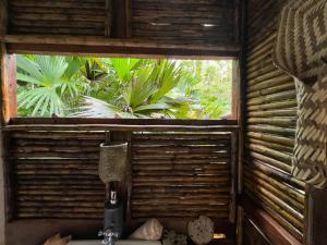 a window in a room with a bottle of wine at Ancestra black ecolodge in Nuquí