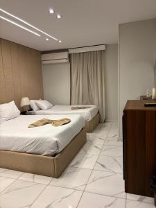 a hotel room with two beds and a desk at Hermes On The Spot Pyramids Hotel in Cairo