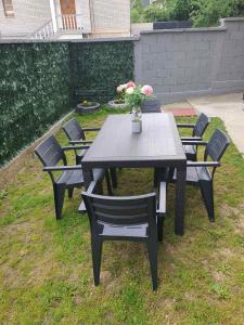 a table and chairs with a vase of flowers on it at Apartman SAN in Sarajevo