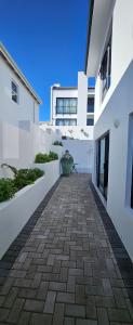 a courtyard of a white building with a potted plant at Sonrisa on Point in Stompneusbaai