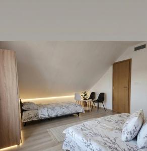 a bedroom with two beds and a table with chairs at Konoba Taline Sokolac in Rešetnica