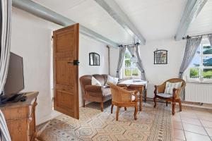 a living room with a tv and a table and chairs at Kieke Wiet in Greetsiel