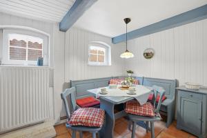 a dining room with a white table and chairs at Kieke Wiet in Greetsiel