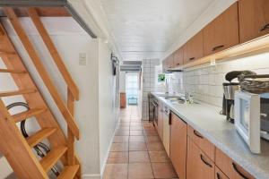 a kitchen with wooden cabinets and a tile floor at Kieke Wiet in Greetsiel +18 photos