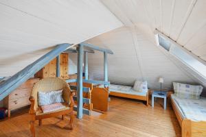 a attic room with a bed and a chair at Kieke Wiet in Greetsiel