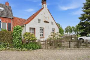 a white house with a fence in front of it at Kieke Wiet in Greetsiel
