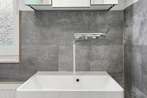 a white sink in a kitchen with aaucet at Kiek In in Greetsiel +19 photos