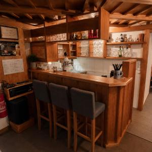 a kitchen with a bar with two chairs at it at Alpinchalet Zigjam in Gaschurn +84 photos