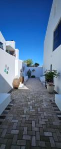 a courtyard of a white building with potted plants at Sonrisa on Point in Stompneusbaai