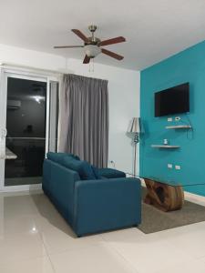 a blue couch in a living room with a ceiling fan at Kingston Condo with Rooftop Pool & Gazebo in Kingston