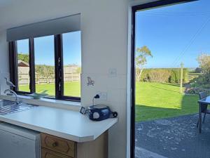 a kitchen with a view of a yard through a window at The Martin's - Uk48870 in Belford +17 photos