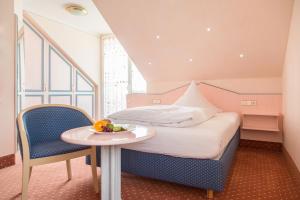 a bedroom with a bed and a table with a bowl of fruit at Hotel-Restaurant Schwedi in Langenargen +72 photos