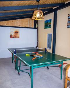 a ping pong table in a living room with a light fixture at Cabana La Cucu in Vadu Moţilor