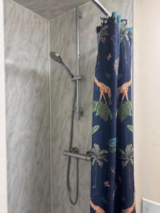 a shower with a blue shower curtain in a bathroom at Sterling Lodge Hotel in Eastbourne +58 photos